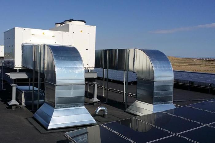 Conductos metálicos y equipos de climatización instalados en la cubierta de un edificio