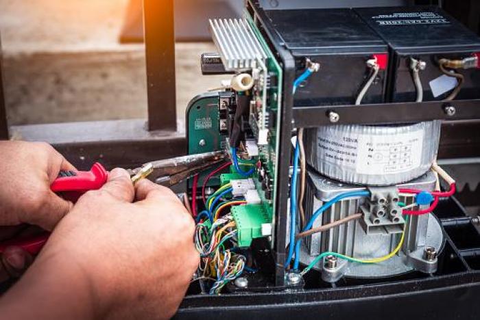 Técnico repara con alicates el cableado interno de un equipo eléctrico industrial