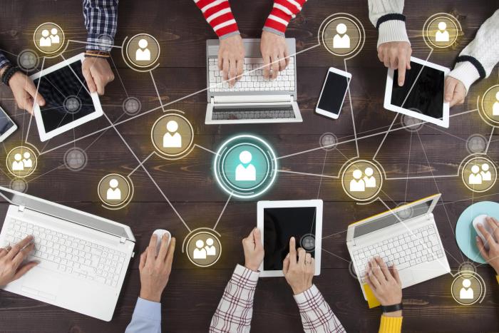 Vista cenital de varias personas con portátiles conectados en una red informática
